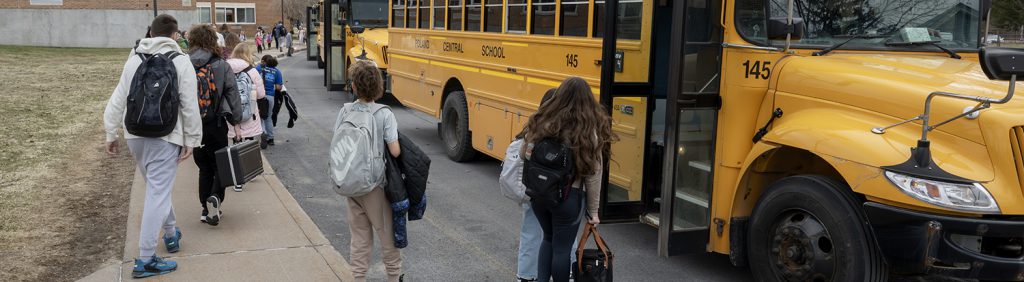 students approaching buses outside the school.