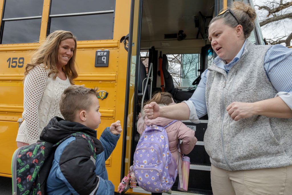 Student giving a fist bump to bus driver