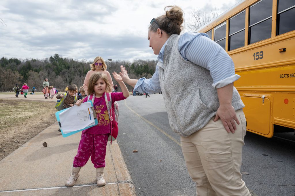 Student giving a high five to bus driver