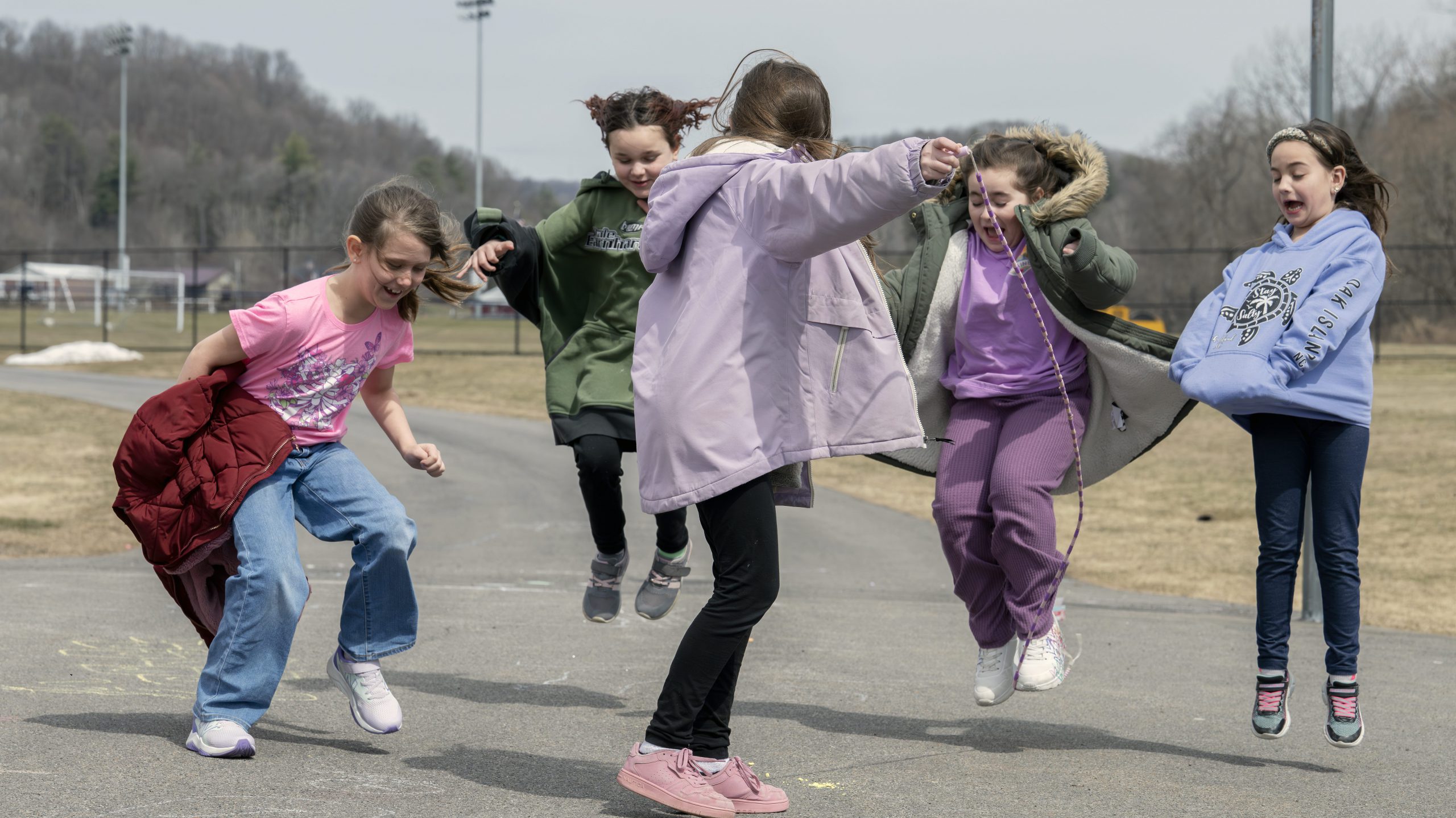 Happy kids playing jump rope together.