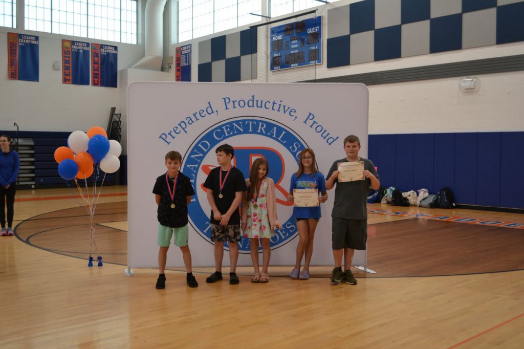 students smiling with awards