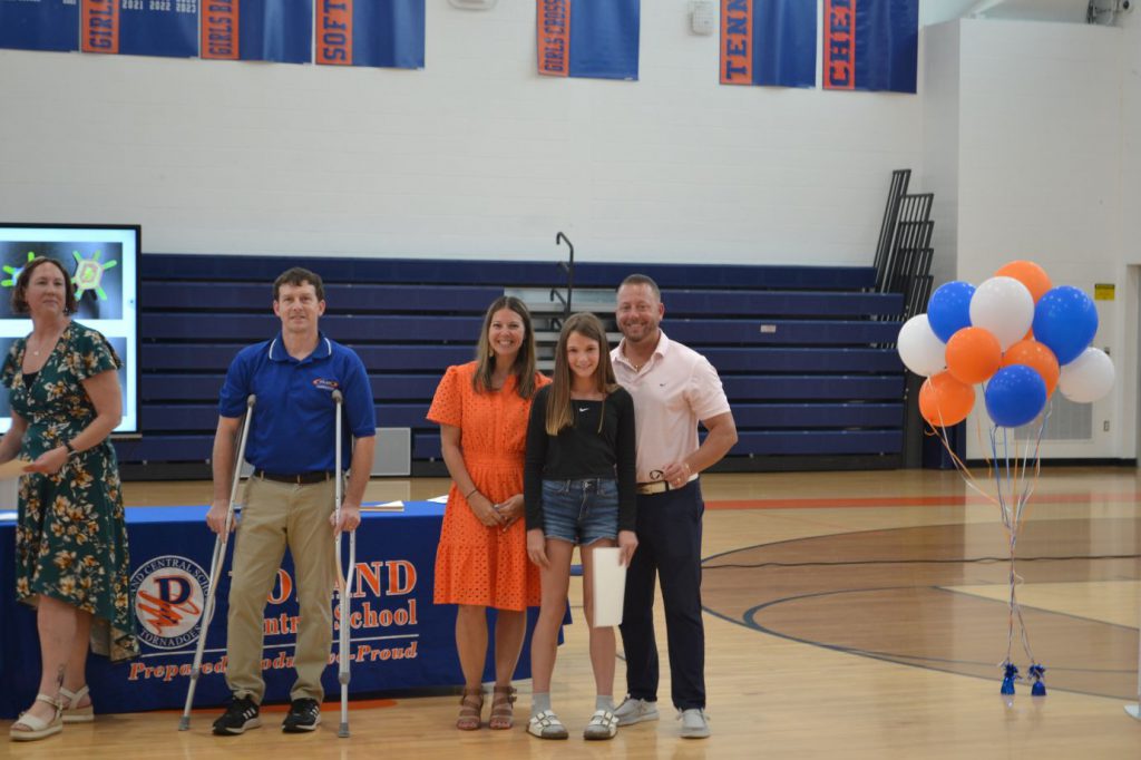 student posing with teachers