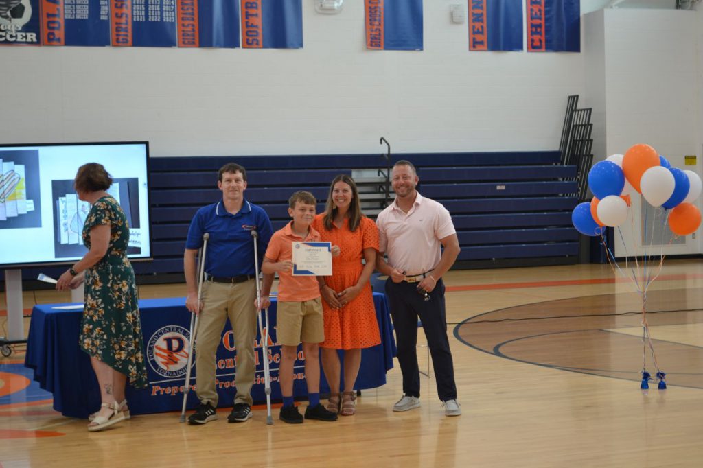 student posing with teachers