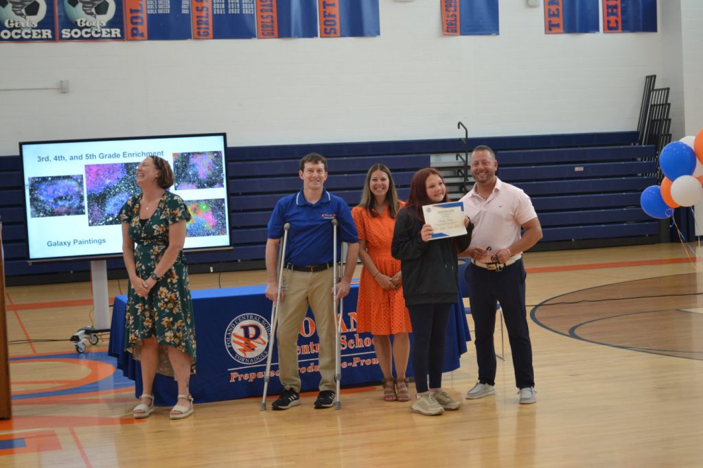 student posing with teachers