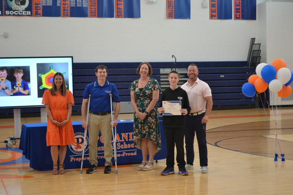 student posing with teachers